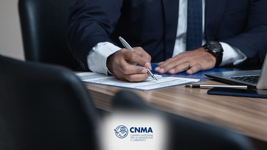 Firma di un documento su cartellina in ufficio - guida allarbitrato CNMA 2026